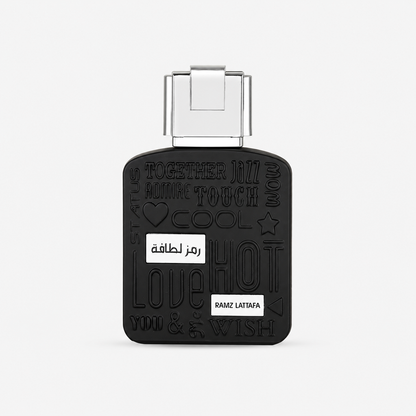 A black rectangular perfume bottle with a silver cap, featuring embossed Arabic and English words including 'LOVE', 'HOT', 'TOUCH', and 'WISH', with two small white labels on the front.