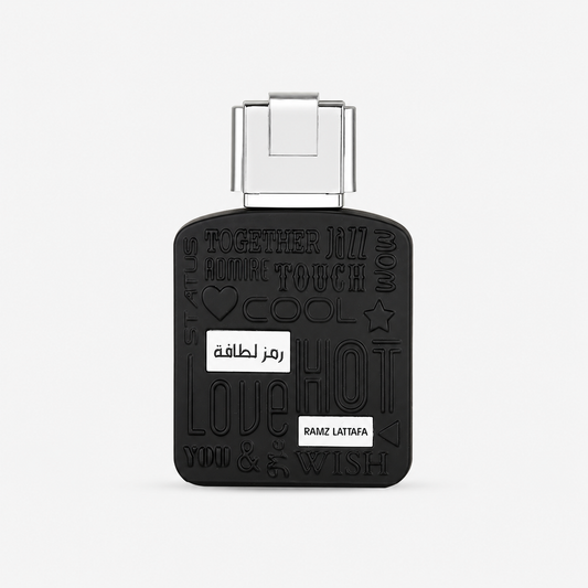 A black rectangular perfume bottle with a silver cap, featuring embossed Arabic and English words including 'LOVE', 'HOT', 'TOUCH', and 'WISH', with two small white labels on the front.