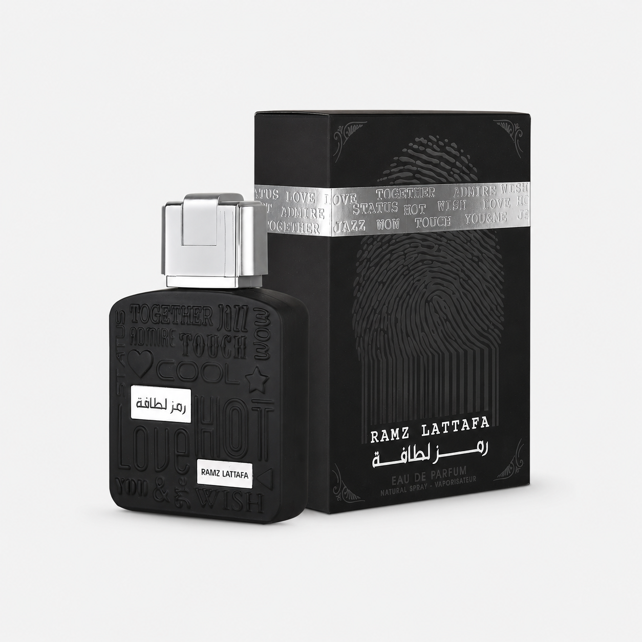 Black Ramz Lattafa perfume bottle with a silver cap next to its black packaging box featuring a fingerprint design and silver band, on a light gray background.