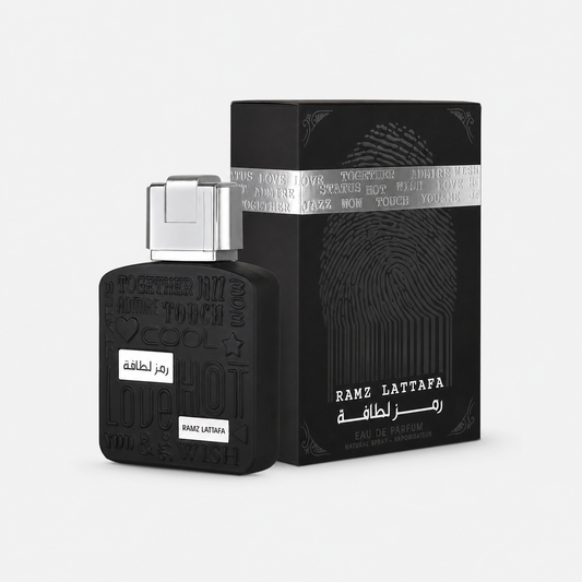 Black Ramz Lattafa perfume bottle with a silver cap next to its black packaging box featuring a fingerprint design and silver band, on a light gray background.