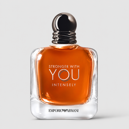 Perfume bottle with orange liquid and black cap on a light gray background